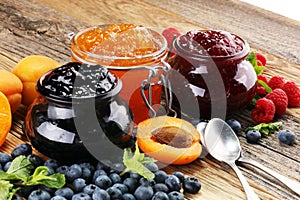 Assortment of jams, seasonal berries, apricot, mint and fruits.