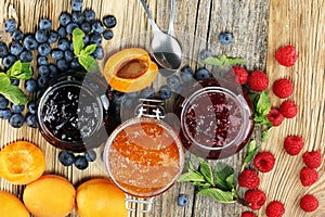 Assortment of jams, seasonal berries, apricot, mint and fruits.