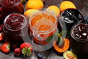 Assortment of jams, seasonal berries, apricot, mint and fruits.