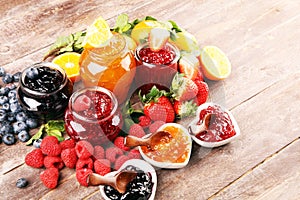 Assortment of jams, seasonal berries jelly, mint and fruits and tangerine