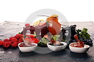 Assortment of jams, seasonal berries jelly, mint and fruits and tangerine