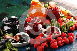 Assortment of jams, seasonal berries jelly, mint and fruits and tangerine