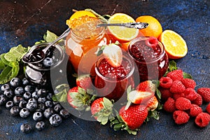 Assortment of jams, seasonal berries jelly, mint and fruits and tangerine