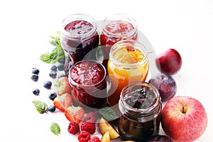 Assortment of jams, seasonal berries, plums, mint and fruits