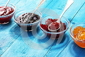 Assortment of jams, seasonal berries, plums, mint and fruits in glass jar