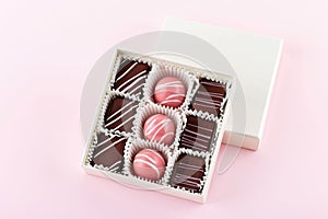 Assortment of luxury bonbons in box on pastel pink background