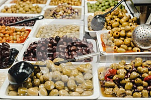 Assortment of olives, pickles and salads on market stand