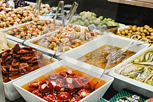 Assortment of olives, pickles and salads on market stand