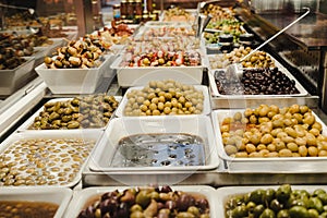Assortment of olives, pickles and salads on market stand