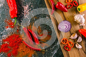 Assortment of peppers, garlic and onions on a stone countertop