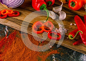 Assortment of peppers, garlic and onions on a stone countertop