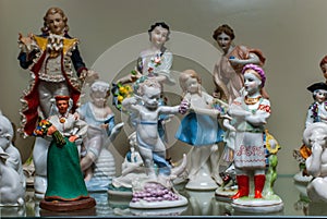 Assortment of rare porcelain figurines on glass shelf