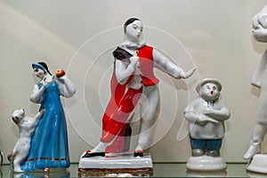Assortment of rare porcelain figurines on glass shelf