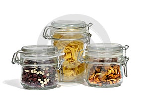 Assortment of raw grains, cereals and pasta in glass jars on a white isolated background. The concept of zero waste. Close-up,