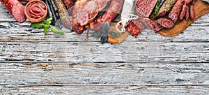 Assortment of salami and snacks. Sausage Fouet, sausages, salami, paperoni. On a white wooden background.