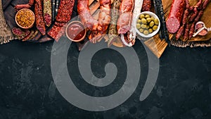 Assortment of salami and snacks. Sausage Fouet, sausages, salami, paperoni. On a stone background.