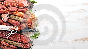 Assortment of salami and snacks. Sausage Fouet, sausages, salami, paperoni. On a black wooden background.