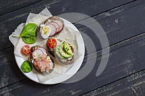Assortment of sandwiches - sandwiches with cheese, radish, cucumber, quail egg, avocado and smoked salmon.