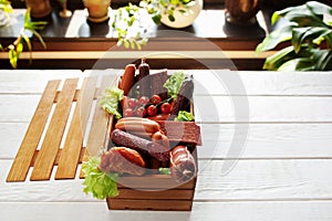 Assortment of sausages in wooden box copyspace