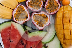 Assortment of sliced tropical fruits on plate.