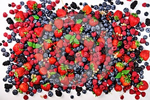 Assortment of strawberry, blueberry, currant, mint leaves. Summer berries background with copy space for your text. Top