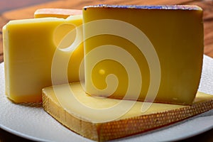 Assortment of Swiss cheeses Emmental or Emmentaler medium-hard cheese with round holes, Gruyere, appenzeller and raclette used for