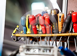 Assortment of tools hanging on wall. Screwdrivers in mechanic garage car service