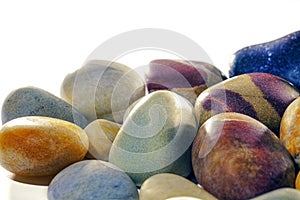Assortment of tumbled beach pebbles studio shot against white ba