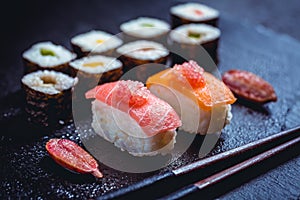 Assortment of vegan sushi with vegetables, seitan, Konjac plant, tofu as fish substitudes, with finger lime as caviar on black