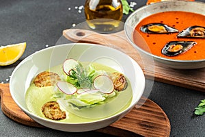 Assortment vegetable soups, tomato soup with mussels and zucchini. Food recipe background. Close up