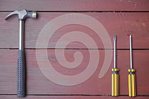 assortment of well-used hand tools spread out on a worn wooden surface, indicative of a workspace or a workbench