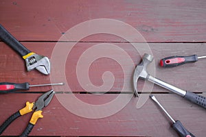 assortment of well-used hand tools spread out on a worn wooden surface, indicative of a workspace or a workbench