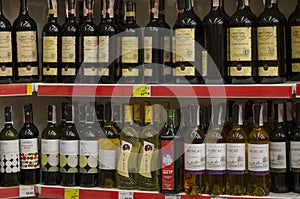 An assortment of wines on a supermarket shelf with price tags