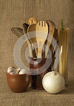 Assortment of Wooden Utensils in a Pennsylvania Redware Vase Arranged with Onion, Garlic, and a Vase of Spaghetti