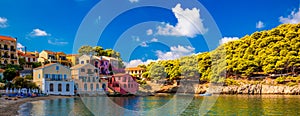 Assos village in Kefalonia, Greece. Turquoise colored bay in Mediterranean sea with beautiful colorful houses in Assos village in