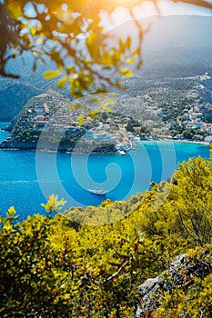 Assos village, Kefalonia. Greece. White yacht in blue bay framed by nature. Turquoise colored bay in Mediterranean sea