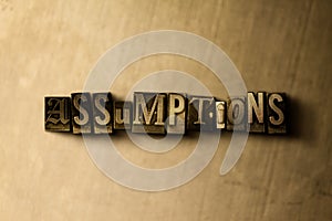 ASSUMPTIONS - close-up of grungy vintage typeset word on metal backdrop photo