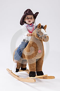 Assured Little Caucasian Girl in Cowgirl Clothing Posing On Symbolic Horse