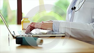 Asthma inhaler with doctor typing on laptop in medical clinic