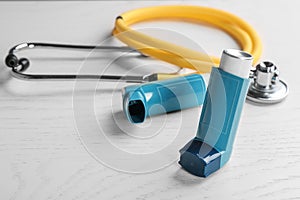 Asthma inhalers and stethoscope on white background