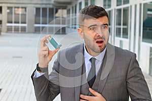 Asthmatic businessman using an inhaler at work