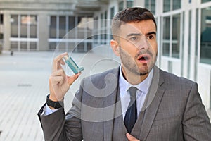 Asthmatic businessman using an inhaler at work