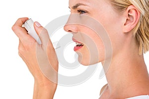 Asthmatic pretty blonde woman using inhaler photo