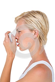 Asthmatic pretty blonde woman using inhaler photo