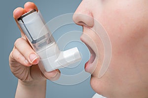 Asthmatic woman suffers from asthma and holds inhaler in hand