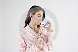 Asthmatic woman using an asthma inhaler during asthma attacks photo