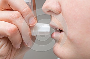 Asthmatic woman is using inhaler photo