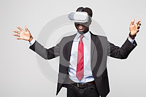 Astonished African businessman in checkered suit experiencing virtual reality while using oculus rift headset