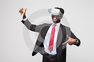 Astonished African businessman in checkered suit experiencing virtual reality while using oculus rift headset