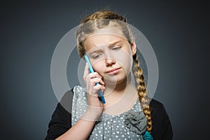 Astonished cute girl with cell phone. isolated on gray